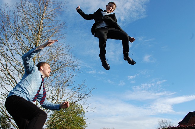 dva muži skákající na trampolíně